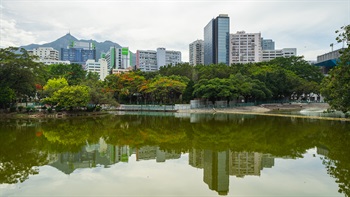 The calm and still water of the man-made lake mirrors the surrounding area and sky.